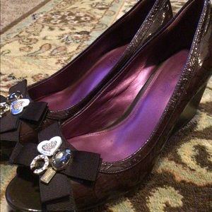 Eye catching patent bedazzled Coach wedges